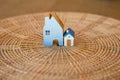 Small house on rattan tray, miniature wooden house with small model house on wood texture background