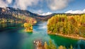 Small house with red roof on the small island. View from flying drone. Sunny morning view of Eibsee lake. Beautifel autumn scene o