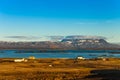 Small houses on the coast of lake on stony rocky deserted landscape of Iceland Royalty Free Stock Photo