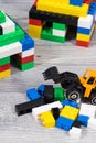 Small houses made of toy blocks and miniature excavator. Development of kids coordination, creativity Royalty Free Stock Photo