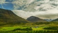 Small houses in the valley among the mountains. Typical Icelandic landscape. A beautiful view of secluded housing.