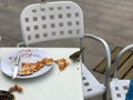 A small hungry bird of sparrows eats from a visitor`s plate in an outdoor cafe on the street Royalty Free Stock Photo