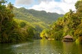 A small hut on tropical river with palm trees, Loboc river, Bohol, Philippines Royalty Free Stock Photo