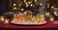 A small illuminated model village toy is displayed with candles on a bokeh Christmas table. quaint,