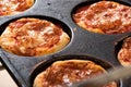 Small individual pizzas in a baking tray