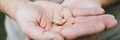 Small intra channel hearing aid device in a man`s hands. banner.