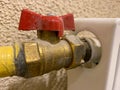 Small iron red industrial shutoff and control valves, plumbing ball valve for shutting off water and liquid flow in a metal yellow