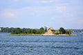 A small island in Helsinki harbour with trees and traditional wooden red house on it. Royalty Free Stock Photo