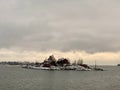 Small island with houses during winter under a gloom sky Royalty Free Stock Photo