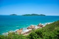 small island in the ocean and a rocky coastline with turquoise-green water, green slopes and an absolutely blue sky Royalty Free Stock Photo