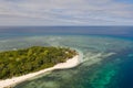 A small island surrounded by azure water and coral reefs, a top view. Royalty Free Stock Photo