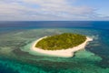 A small island surrounded by azure water and coral reefs, a top view. Royalty Free Stock Photo