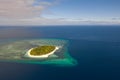 A small island surrounded by azure water and coral reefs, a top view. Royalty Free Stock Photo