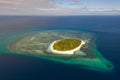 A small island surrounded by azure water and coral reefs, a top view. Royalty Free Stock Photo