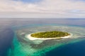 A small island surrounded by azure water and coral reefs, a top view Royalty Free Stock Photo