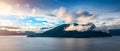 a small island is surrounded by clouds and the ocean on a beautiful day