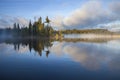 Small island with trees on a foggy northern Minnesota lake at sunrise in September Royalty Free Stock Photo