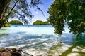 View through trees to overgrown karst islands, Palau, light blue and turquoise water of Pacific Ocean.