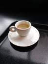Small Ivory White Demitasse Espresso Cup with Matching Saucer on a Black Serving Tray, Coffee Foam Inside of the Cup