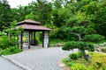 Small Japanese style gazebo in park next to bonsai tree