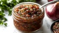 small jar of bacon jam with spoon dipping into it surrounded by fresh herbs and onions, creating savory and appetizing scene Royalty Free Stock Photo