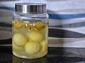 Small jar filled with salted gooseberries on a table