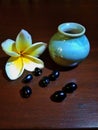 Small jar with frangipani flowers and grains