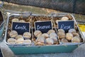 Small jars of handmade natural cosmetics, lip balm and blush, on display in a vintage metal basket