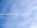 Small jets in distance create chem-trails across blue sky