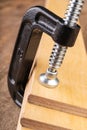 A small joinery clamp used for gluing planks. Accessories for carpenters on the workshop table Royalty Free Stock Photo