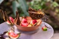 Small kaleidoscope of owl butterflies feeding on fruit in a bowl on a garden table