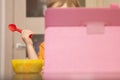 Small kid eats soup sitting behind tablet pc and only his hand and a bowl of food are visible Royalty Free Stock Photo