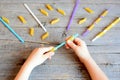 Small kid holds straw and dried tube pasta in his hands. Kid stringing pasta onto straw