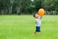 Small kid play with orange balloon Royalty Free Stock Photo