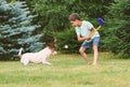 Small kid playing golf at backyard lawn and dog intercepting and catching ball Royalty Free Stock Photo