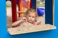 Small kid playing with sand at playground. Little girl at sandbox in park. Royalty Free Stock Photo