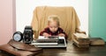 Small kid typewrite paper on retro typewriter at desk. Boy typewrite keys on vintage machine Royalty Free Stock Photo