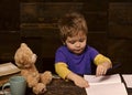 Small kid writing in textbook. Diligent boy learning letters. Early learning concept Royalty Free Stock Photo