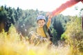 Small kid in yellow sweater walking with mother in autumn forest