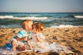 Small kids are kissing and having fun at beach together near the ocean, happy lifestyle family concept Royalty Free Stock Photo