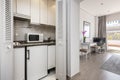 Small kitchen of an apartment with a small fridge under the gray granite