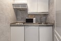 Small kitchen of an apartment with a small fridge under the gray granite