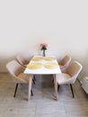 Small kitchen corner with white walls, a dining table and beige armchairs.