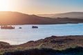 Small lake with blue water and wild fields. Beautiful sun rise scene in Connemara, county Galway, Ireland. Warm and cool tones.