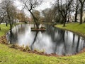 Small lake in the city of Jever, Germany, receiving raindrops on a cold winter day