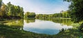 Small lake located in park in Siemianowice Slaskie, Silesia, Poland. Natural coastline covered with grass. Tranquil water surface Royalty Free Stock Photo