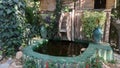 A small lake and a small mill over a pool in garden