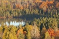 Small lake among trees with fall color in northern Minnesota Royalty Free Stock Photo