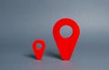 Small and large red navigational location indicators. The concept of a more significant and popular place. Competition. Arrival