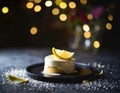 Small lemon cake, decorated with a thick layer of icing and a slice of lemon, dark background